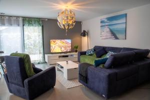 ein Wohnzimmer mit 2 Sofas und einem TV in der Unterkunft Maison meublée Divonne-les-Bains in Divonne-les-Bains