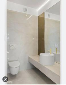 La salle de bains blanche est pourvue d'un lavabo et de toilettes. dans l'établissement Luxury Wellness&Spa, à Bucarest