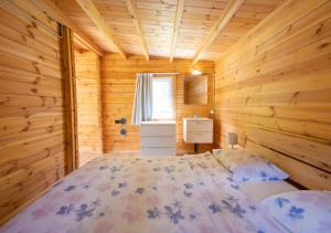 a bedroom with a bed in a wooden cabin at Camping Piccolo Paradiso in Avegno