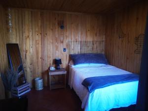1 dormitorio con 1 cama y pared de madera en Linda vista en San Pedro La Laguna