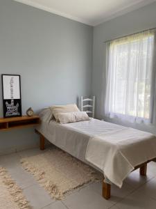 a bed in a white room with a window at Kalimera in Lago Puelo