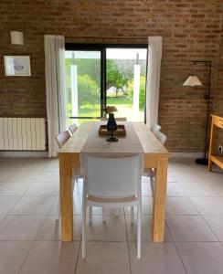 a dining room with a wooden table and chairs at Kalimera in Lago Puelo