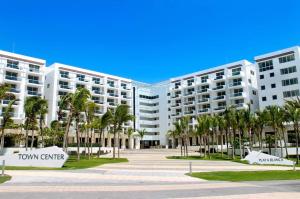 un gran edificio de apartamentos con palmeras enfrente en Playa Blanca Town Center Suites, en Río Hato