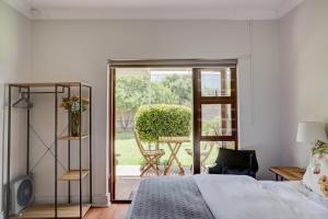 a bedroom with a bed and a door to a patio at Beautiful Abalone in Hermanus