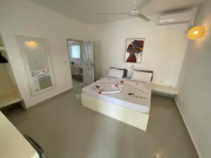 Ascot Watamu في واتامو: غرفة كبيرة بها سرير ومرآة