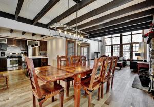 a kitchen and dining room with a wooden table and chairs at Chalet 9001 Chemin des Alpages by Les Chalets Alpins in Stoneham