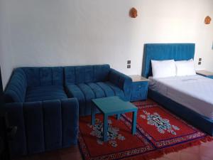 沃利迪耶的住宿－Sultana duplex 1 pour les familles，客厅配有蓝色的沙发和床。