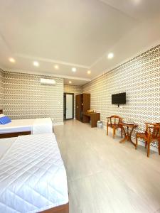 um quarto com uma cama e uma televisão na parede em Ngọc Mai Hotel em Rạch Giá
