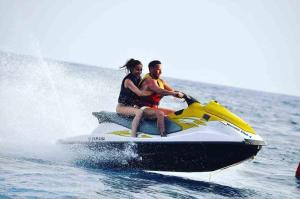 a man and woman riding on a jet ski in the water at FLOBESTIAN BEACH VILLA CANDOLIM BEACH in Aguada