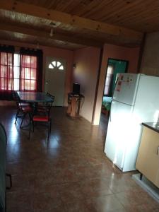 uma sala de estar com uma mesa e um frigorífico em Relax Serrano em Santa María
