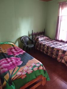 1 dormitorio con 2 camas y una mesa con flores en Relax Serrano en Santa María
