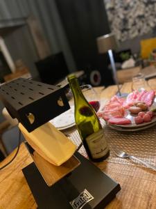 a wooden table with a bottle of wine and a knife at La maison du Lac in Spa