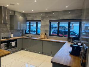 a kitchen with a counter and some windows at Broadway Beach Home with Hot tub in Herne Bay