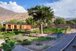 a house in the middle of a garden with train tracks at Glamping El Obrador Tilcara in Tilcara