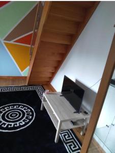 a room with a desk with a tv and a table at Maison d'hôte la Courneuve in La Courneuve