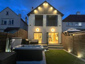 a white house with a hot tub in the yard at Broadway Beach Home with Hot tub in Herne Bay