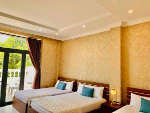 um quarto com 2 camas e uma janela em Ngọc Mai Hotel em Rạch Giá