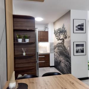 Habitación con puerta corredera, escritorio y sillas. en Komfortowy apartament en Toruń