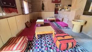 an empty room with two beds and a table at Dar Yaya in Mhamid