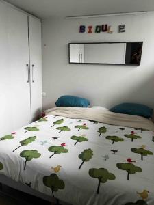 um quarto com uma cama com um cobertor com árvores em Loft 80 m2 aux portes de Paris, La Défense et proche Versailles em Puteaux