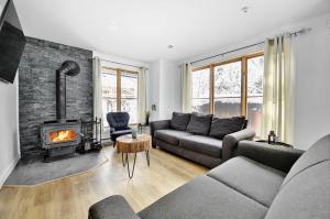 a living room with a couch and a fireplace at Chalets Alpins - 01 Chemin Alpin in Stoneham