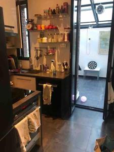 uma cozinha com um lavatório e uma porta para um quarto em Loft 80 m2 aux portes de Paris, La Défense et proche Versailles em Puteaux