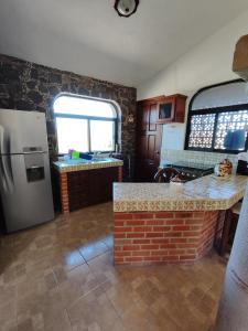 a kitchen with a refrigerator and a counter in it at Casa rústica de campo in Tecozautla
