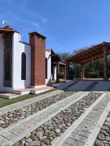 a stone walkway next to a building with a brick pillar at Casa rústica de campo in Tecozautla