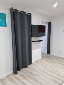 cortina negra en una habitación con TV en Au Petit Ronceraie en Blois