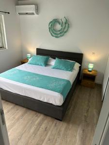 - une chambre avec un grand lit et des oreillers bleus dans l'établissement Pension Irivai, appartement UO UO 3 chambres vue mer, à Uturoa