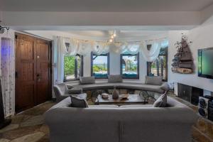 uma sala de estar com um sofá e uma mesa em Efharis Beachfront Villa em Platamon