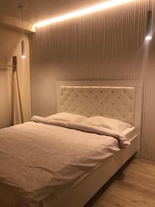 un letto con testiera bianca in una stanza di Vip Sadyba Svalyava Apartment a Svalyava