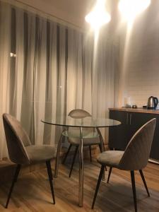 スバリャバにあるVip Sadyba Svalyava Apartmentのキッチン付きの客室で、テーブルと椅子が備わります。