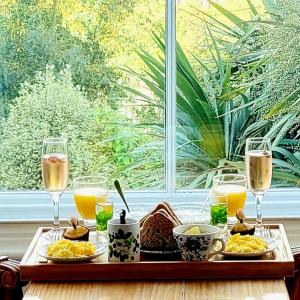 a table with a tray of food and glasses of wine at West Hill Villa Retreat Edwardian City View Ensuite with Room Served Breakfast & Free Parking in Hastings