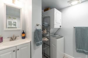 a white bathroom with a sink and a shower at Laurelhurst - Cozy 1 Bedroom Apt Near Children’s Hospital and UW in Seattle +8 photos
