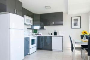 a kitchen with black and white appliances and a table at Beautiful Downtown & Bay Bridge, Vineyard Views! in San Francisco