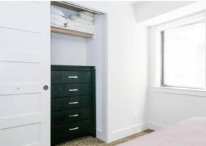a closet with a black dresser and a window at Beautiful Downtown & Bay Bridge, Vineyard Views! in San Francisco