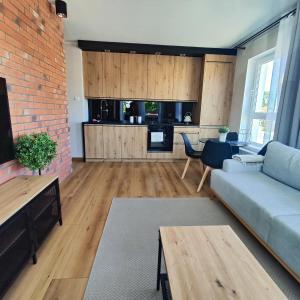 uma sala de estar com um sofá e uma cozinha em Asti Apartamenty Centrum Stargard em Stargard