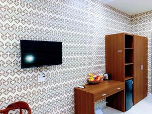 um quarto com uma televisão na parede em Ngọc Mai Hotel em Rạch Giá