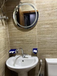 een badkamer met een wastafel en een spiegel aan de muur bij Aton pyramids INN in Caïro