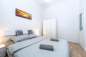 um quarto branco com uma cama e uma fotografia na parede em Stunning Wenceslas Square apartment em Praga