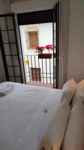 a bedroom with a bed and a balcony with a window at MiRa San Basilio in Córdoba
