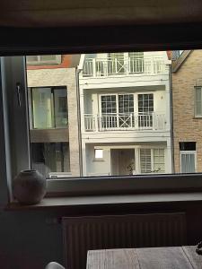 ein Fenster mit Blick auf ein Gebäude in der Unterkunft Le Knok'Koon Un cocon à Knokke avec garage et emplacement gratuits in Knokke-Heist