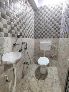 a bathroom with a toilet and a sink at OYO The Pine & Dine in Sonpur