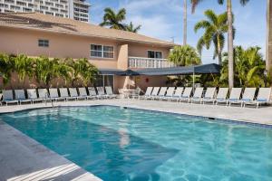 a swimming pool with lounge chairs and a building at Coconut Bay Resort in Fort Lauderdale