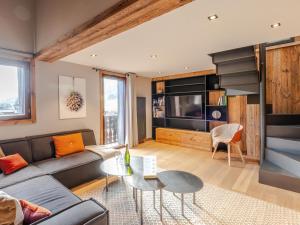 un salon avec un canapé et une table dans l'établissement Duplex rénové au centre avec garage double et wifi - FR-1-754-11, à Morzine