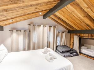 une chambre avec un lit avec deux serviettes dessus dans l'établissement Duplex rénové au centre avec garage double et wifi - FR-1-754-11, à Morzine