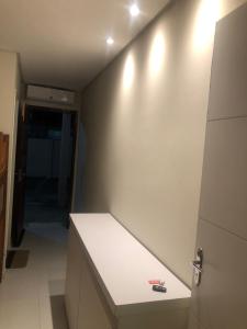 Flat barra de São Miguel BSM Porto venezia في بارا دي ساو ميجيل: مطبخ مع منضدة بيضاء وأضواء على الحائط