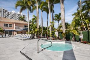 a hot tub in a courtyard with palm trees at Coconut Bay Resort in Fort Lauderdale