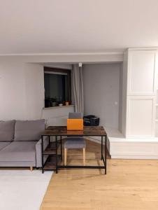 a living room with a couch and a table with a laptop at Apartament z biokominkem blisko lotniska in Warsaw